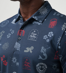 A TravisMathew golf polo in the color blue, with golf simples, drinking simpples, and "here for a good time" across the entire shirt. Titled the Julyin Polo.