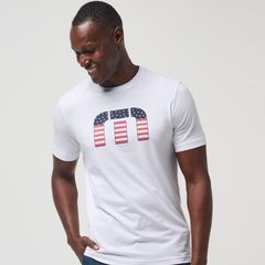 A white men's t-shirt from TravisMathew, with the iconic TravisMathew logo on the chest. Filled in with the American Flag.
