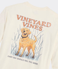 Long sleeve t-shirt with the graphic of a golden retriever dog on the back. Above the dogs is, "Vineyard Vines." Below the dog is the phrase, "EVERY DAY SHOULD FEEL THIS GOOD." The dog is standing in high grass, and the t-shirt is the color marshmallow.