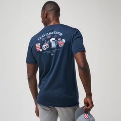 A full view of the backside of the blue TravisMathew Chug It Out shirt.