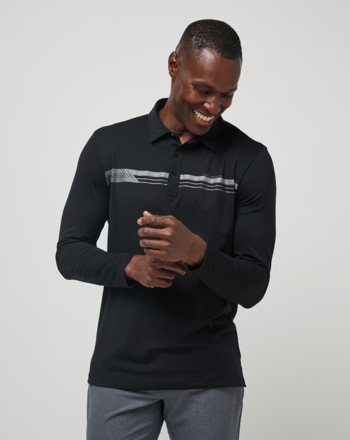 Course Mapper Long Sleeve Polo in all black. Featuring a grey stripe logo across the chest. The polo comes from the brand TravisMathew.