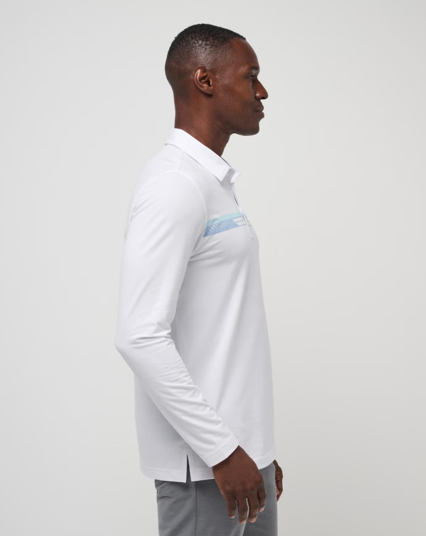 Course Mapper Long Sleeve Polo in all white. Featuring a blue stripe logo across the chest. The polo comes from the brand TravisMathew.