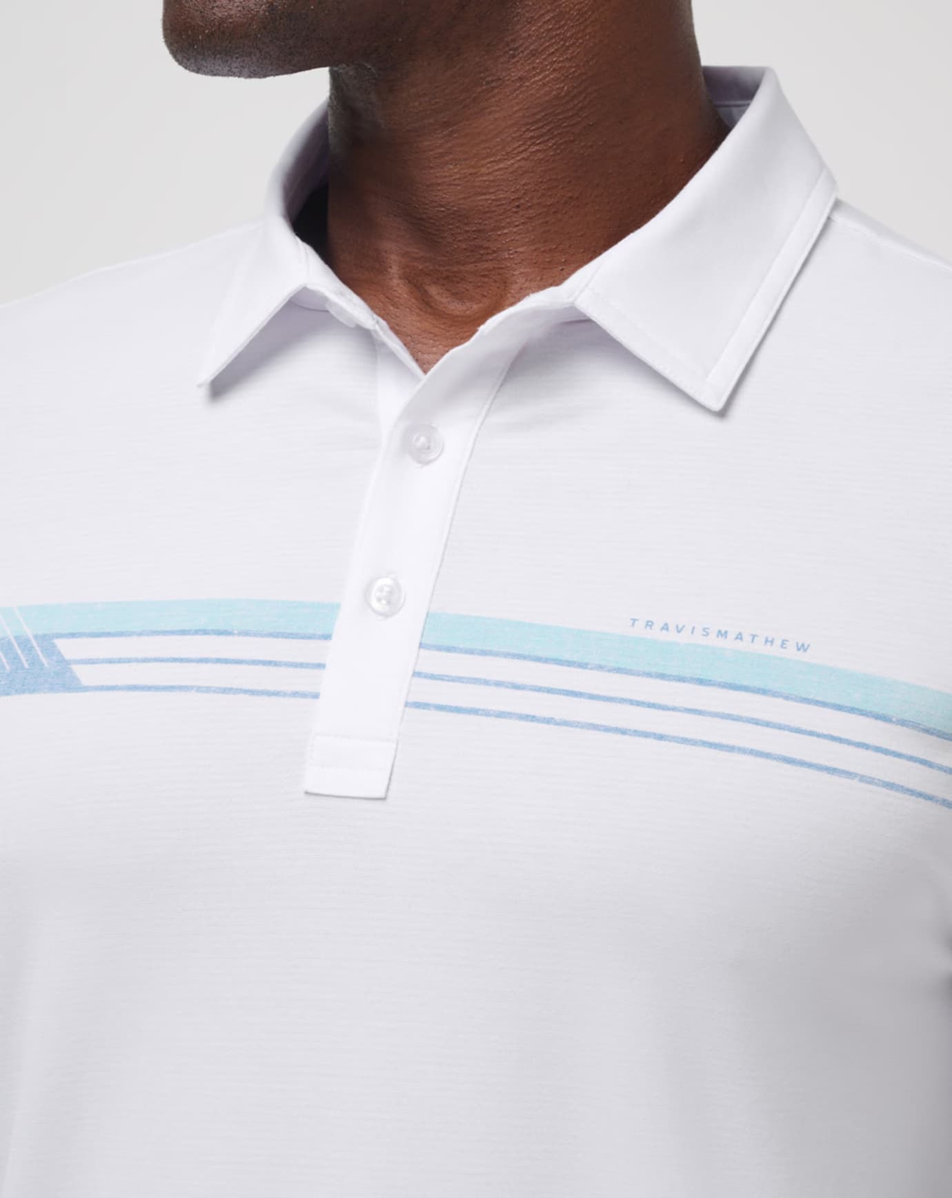 Course Mapper Long Sleeve Polo in all white. Featuring a blue stripe logo across the chest. The polo comes from the brand TravisMathew.