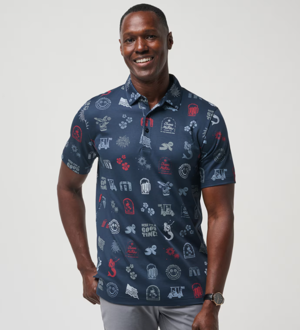 A TravisMathew golf polo in the color blue, with golf simples, drinking simpples, and "here for a good time" across the entire shirt. Titled the Julyin Polo.