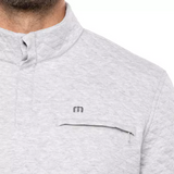 Close up of the chest pocket with zipper closure, showing the TravisMathew logo just above the pocket.