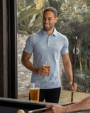 TravisMathew Men's The Zinna Polo in the color heather light blue.