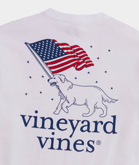 A Vineyard Vines pocket t-shirt showing a dog carrying an American flag in it's mouth.