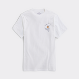 A white t-shirt from Vineyard Vines. Showing a fishermen wearing a yellow wet suit, riding a large mouth bass fish, with a fishing hook in front of it's mouth.