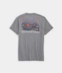 Vineyard Vine Men's T-Shirt in the color grey, showing a bonfire pit with 2 empty chairs, and a cooler with am American Flag on the side.