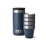 4 blue shot glasses stacked together, sitting next to a navy blue travel case with a silver YETI logo on the front.