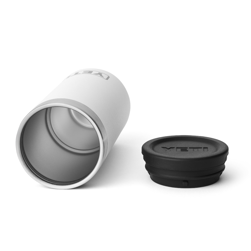 A white shot glass case on its side showing a stainless steel interior, and a black lid with the YETI logo engraved into the top.