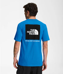 North Face Men's Short Sleeve Box NSE Tee In Blue, showing the back logo graphic that reads "The North Face, never stop exploring."