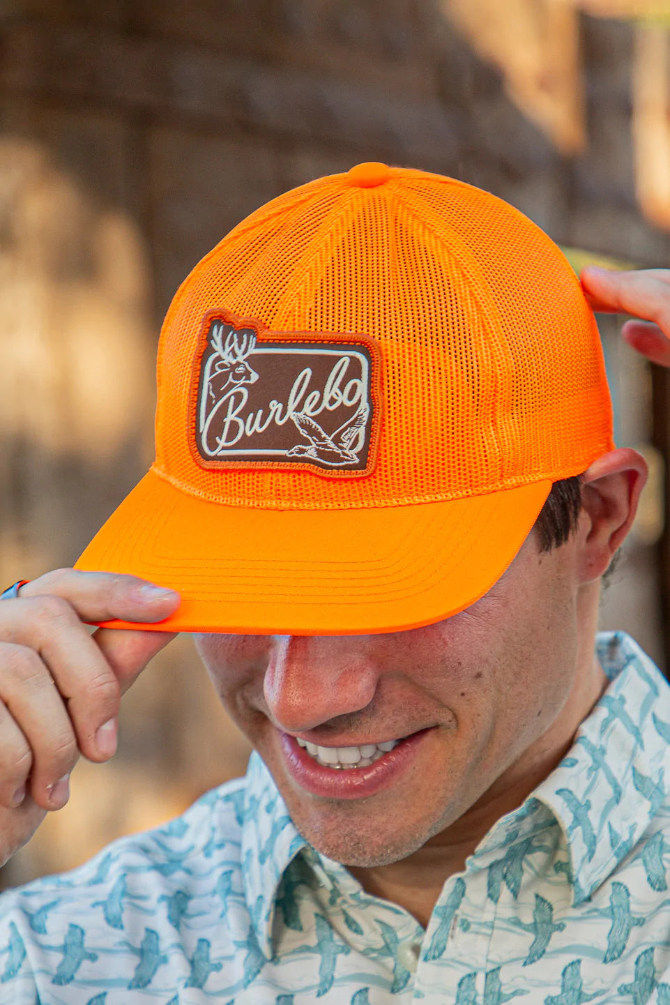 Front view of an orange Burlebo mesh back hat